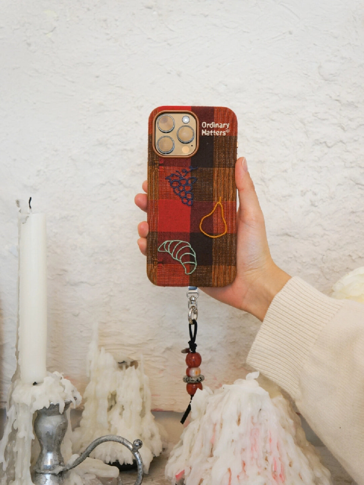 Embroidered phone case with colorful fruit and bread designs, made by TRLab Shop, showing detailed stitched artwork.