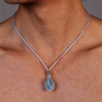 Aquamarine hand-woven cord necklace featuring a vibrant blue gemstone pendant on a natural cord, displayed against a neutral background.