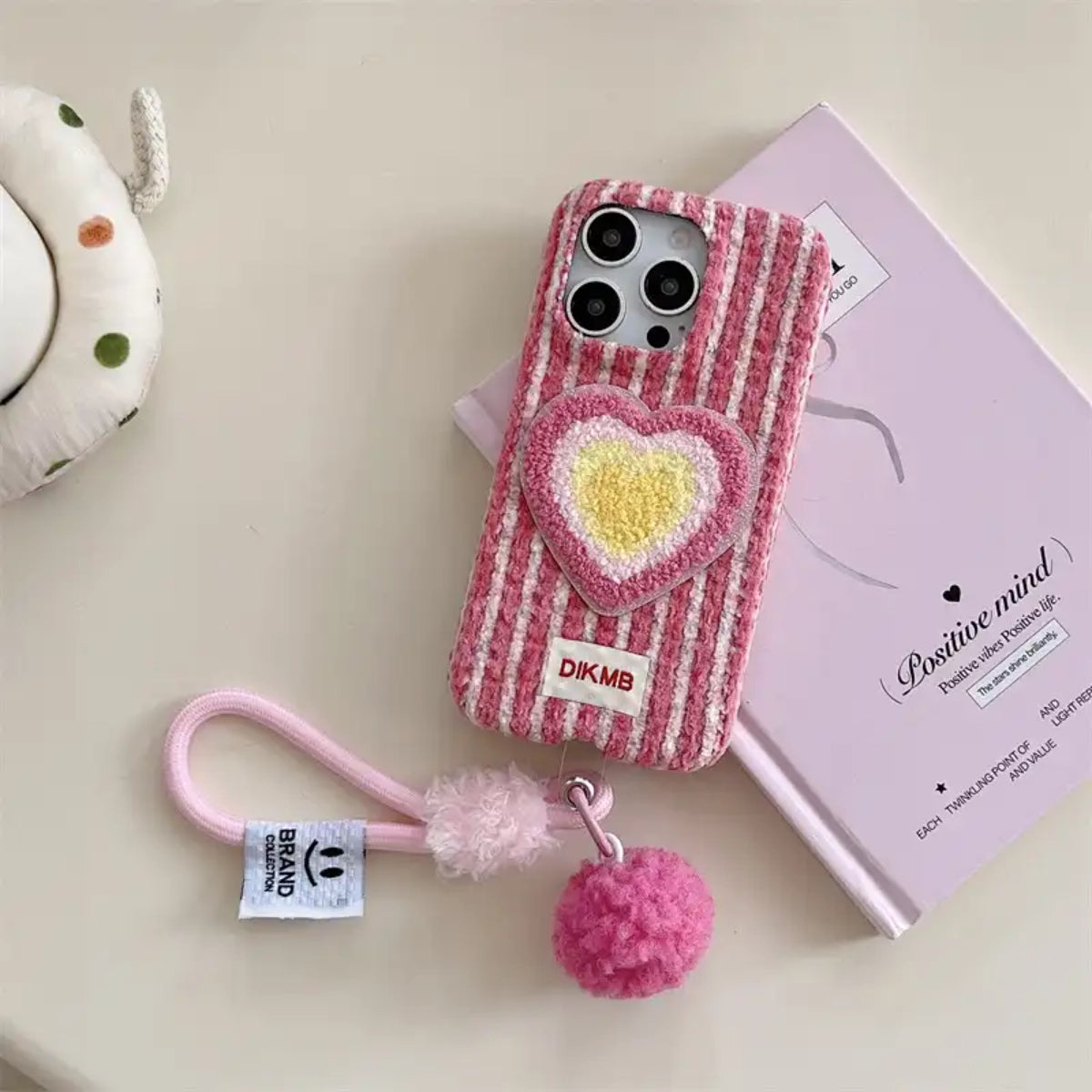 Pink love heart embroidered phone case by TRLab Shop featuring delicate heart designs on a soft pink background.
