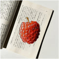 Translucent fruit-shaped acrylic bookmark with colorful fruit illustrations, ideal for marking pages in books.