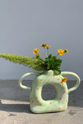 Ceramic donut-shaped twin-handled vase by UNBELDI with a glazed finish, designed for decorative floral arrangements.