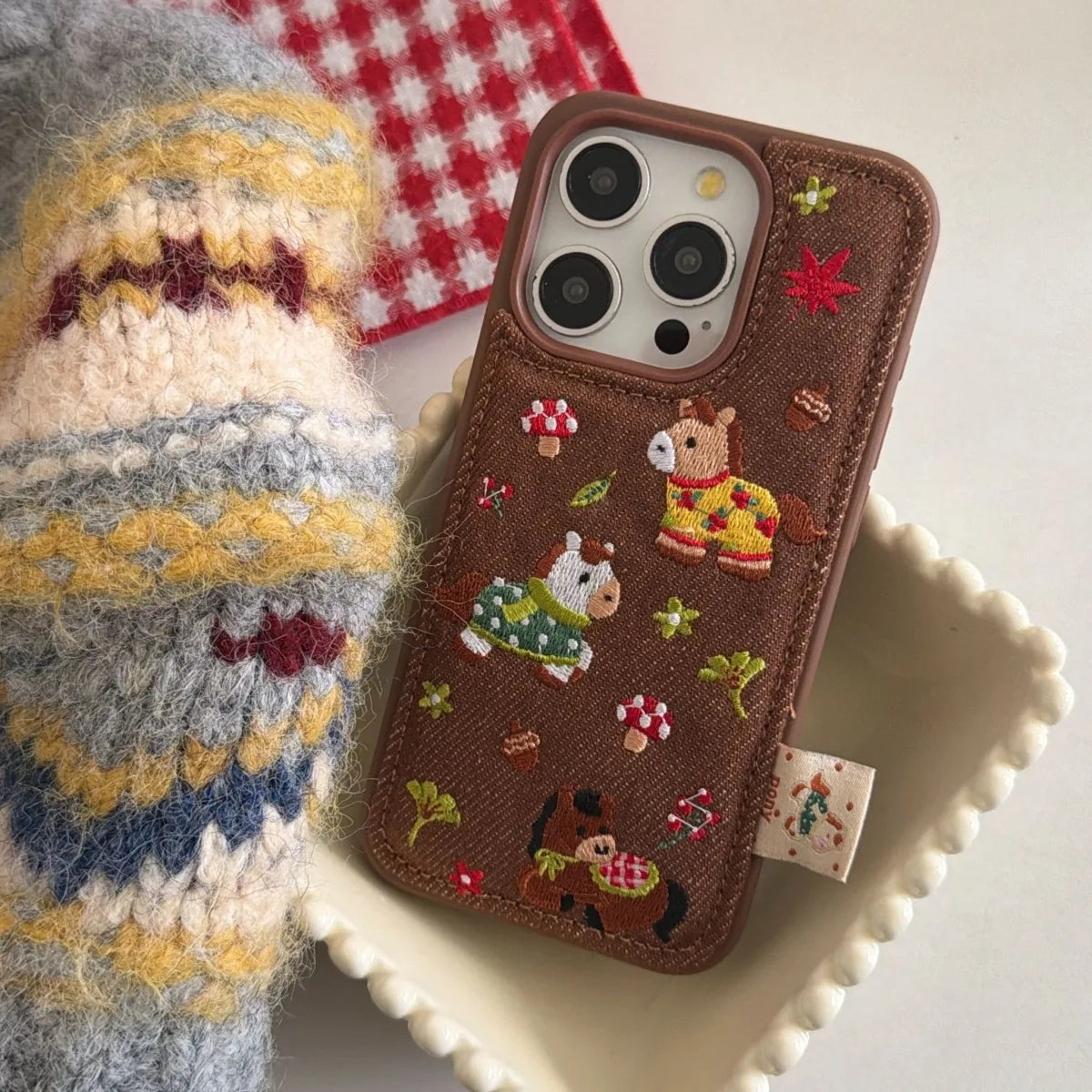 Embossed pony embroidery on a TRLab Shop phone case, showcasing detailed colorful stitching and a protective design.