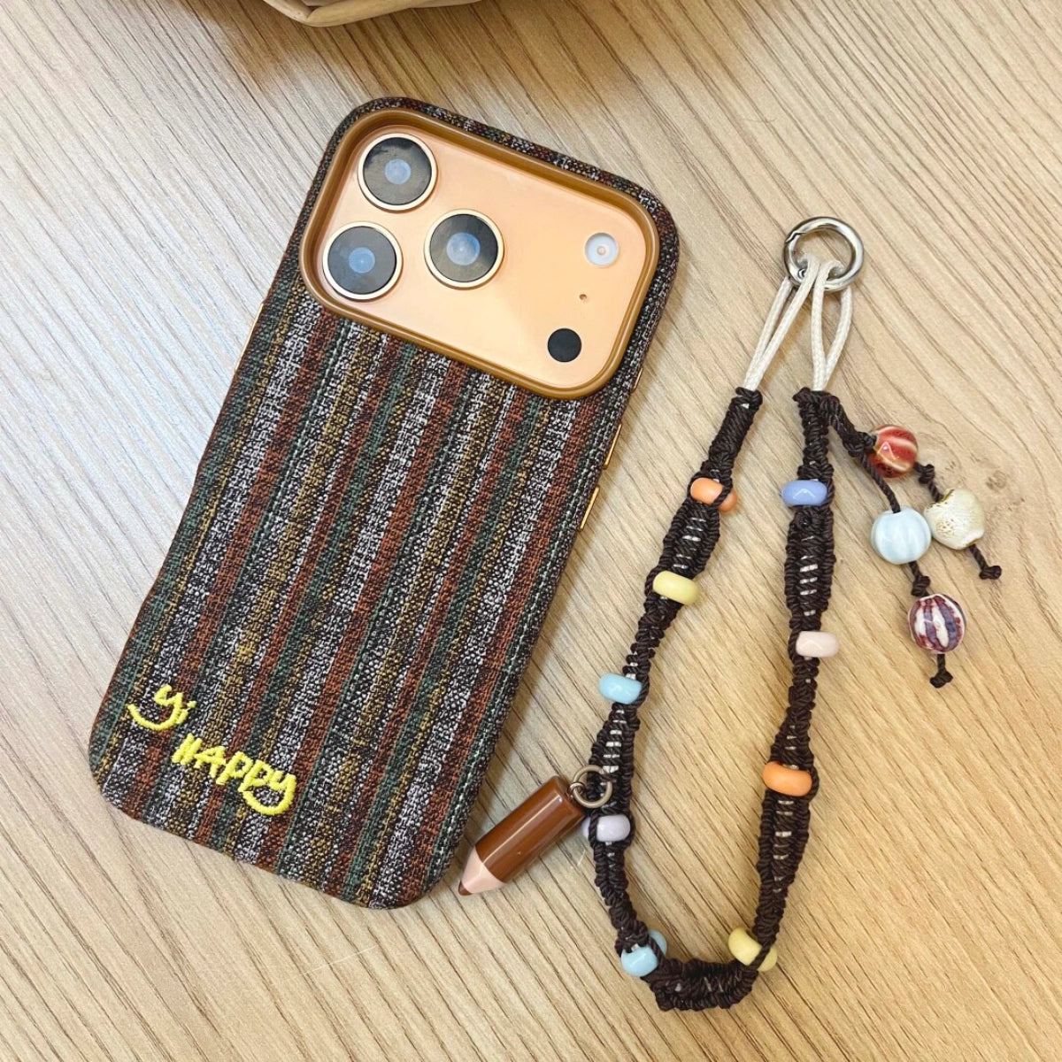 Embroidered phone case with colorful Happy Letters design by TRLab Shop, showing detailed stitching and vibrant patterns.
