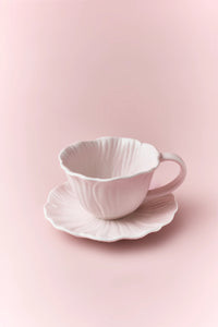 Ceramic floral cup and saucer set featuring colorful flower patterns on white background, perfect for tea or coffee.