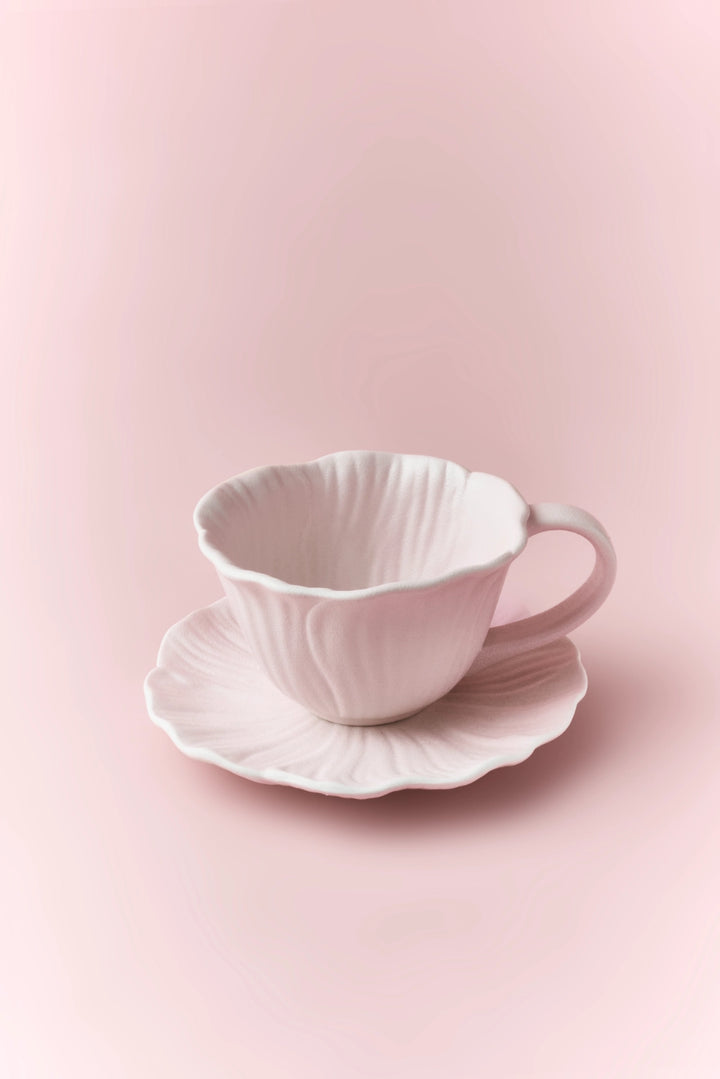 Ceramic floral cup and saucer set featuring colorful flower patterns on white background, perfect for tea or coffee.