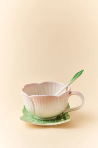 Pink ceramic Begonia cup and saucer set with matching spoon, elegant and decorative for tea or coffee presentation.