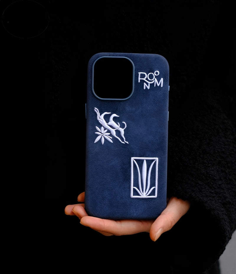 Blue shamanic embroidered phone case with intricate tribal designs, made by TRLab Shop, showcasing detailed embroidery on the fabric surface.