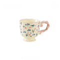 Floral twisted-handle ceramic mug with colorful flower design, durable white ceramic, ideal for hot beverages.
