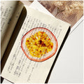 Translucent fruit-shaped acrylic bookmark with colorful fruit illustrations, ideal for marking pages in books.
