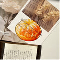 Translucent fruit-shaped acrylic bookmark with colorful fruit illustrations, ideal for marking pages in books.