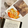 Translucent fruit-shaped acrylic bookmark with colorful fruit illustrations, ideal for marking pages in books.