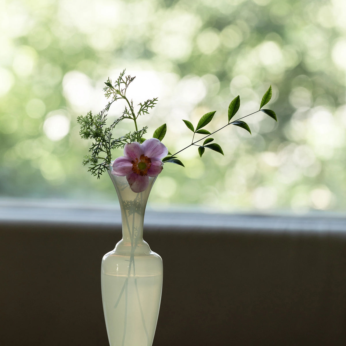 Elegant waisted glass vase by TRLab Shop featuring a clear, smooth surface and a stylish, curved design for floral arrangements.
