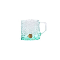 Glacier-textured gradient glass mug by TRLab Shop with a smooth handle, showcasing a cool blue and clear glass design.