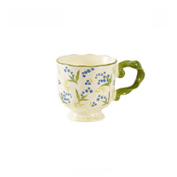 Ceramic mug with floral pattern and twisted handle, designed by TRLab Shop, featuring colorful flower motifs on a white background.
