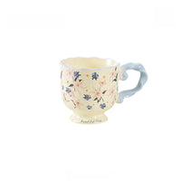 Ceramic mug with floral pattern and twisted handle, designed by TRLab Shop, showcasing a stylish and colorful coffee cup.