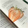 Translucent fruit-shaped acrylic bookmark with colorful fruit illustrations, ideal for marking pages in books.