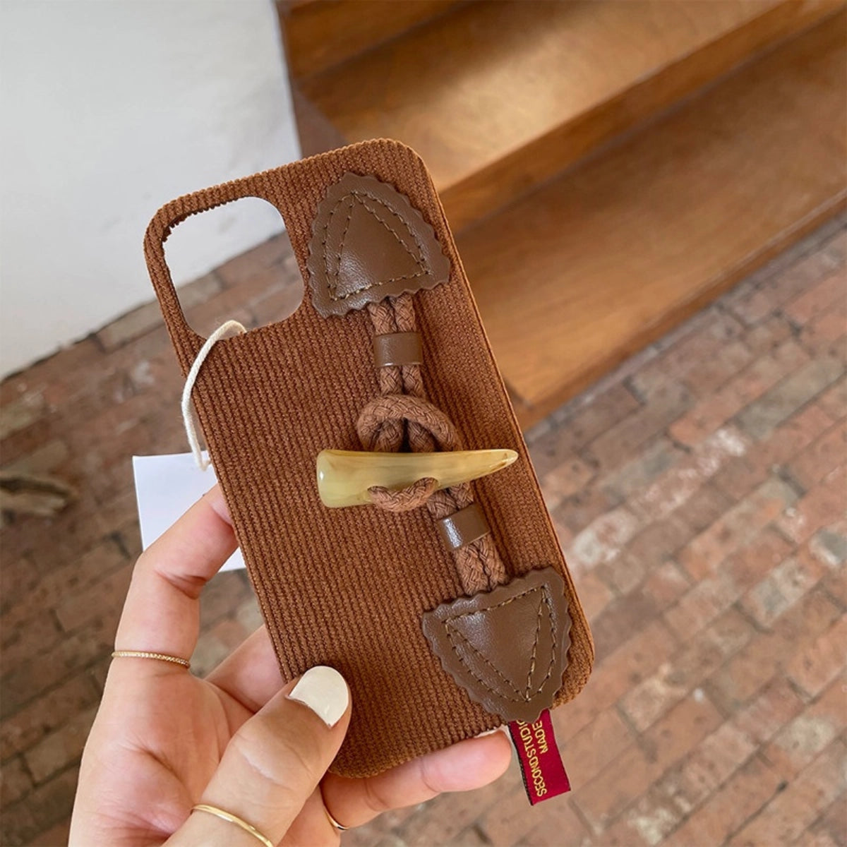 Striped corduroy fabric phone case with toggle button closure, designed by TRLab Shop, featuring a stylish and protective design.