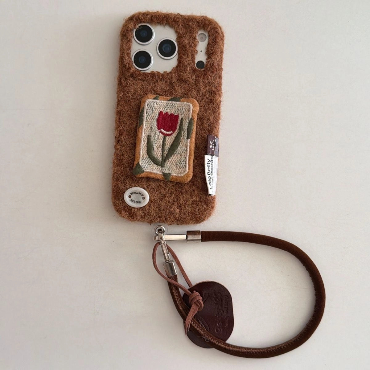 Embossed tulip embroidery on TRLab Shop phone case, showing intricate floral design and protective case structure.