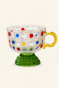 Colorful polka-dot cane-weave glass cup with vibrant rainbow patterns, showcasing intricate glasswork and bright, cheerful design.