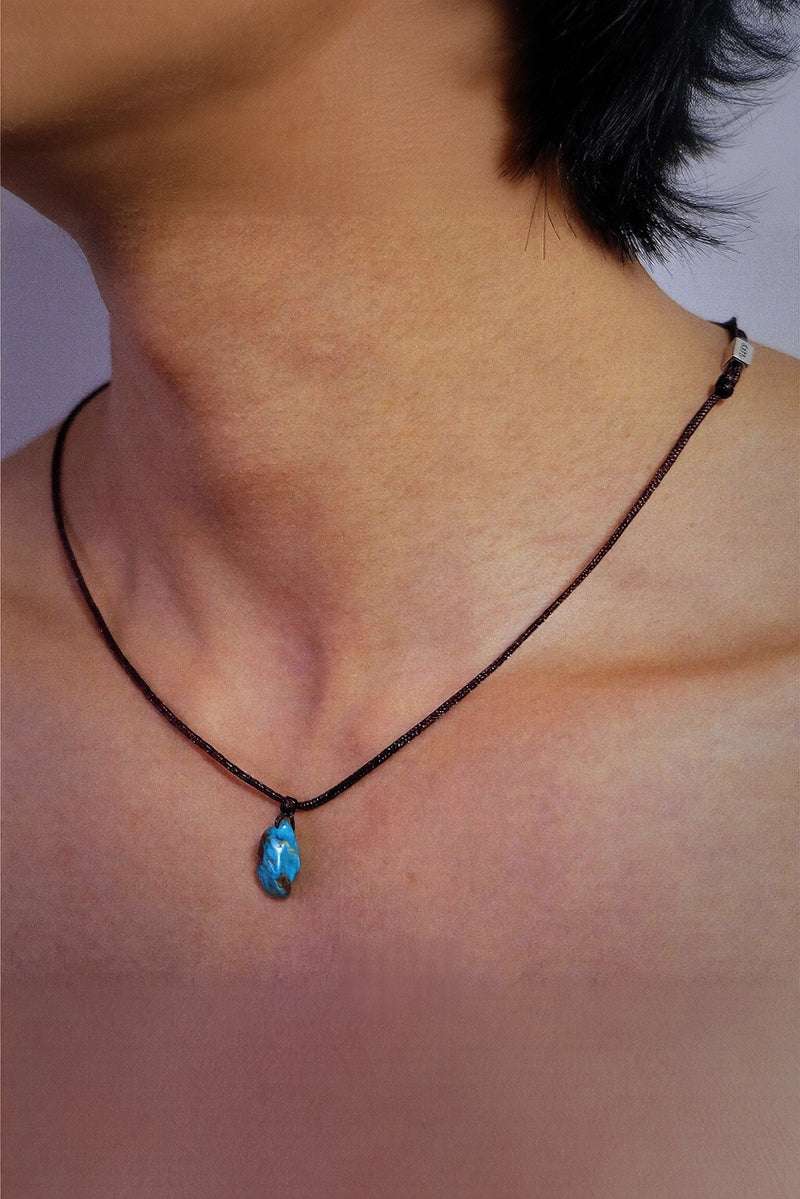 Turquoise hand-woven cord necklace with intricate knot details, crafted by TRLab Shop, displayed on a neutral background.