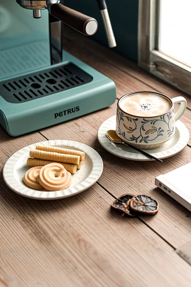 Retro floral ceramic coffee cup and saucer set with vibrant flower patterns, perfect for vintage-inspired coffee presentation.