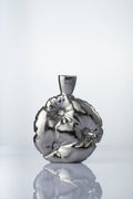 Two iridescent vases with white orchids on a beige surface and background